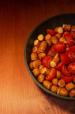 Bir tavada küçük İtalyan domates ile Kızarmış sosis th