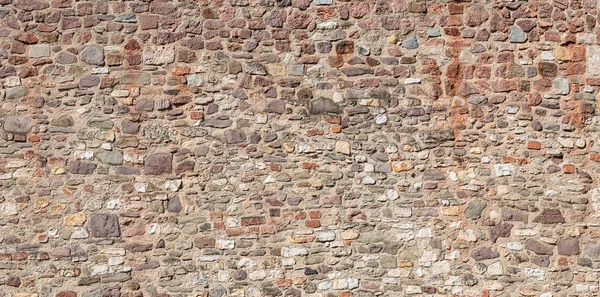 Antigua muralla fortaleza de mediana edad con patrón de ladrillos y piedras i — Foto de Stock