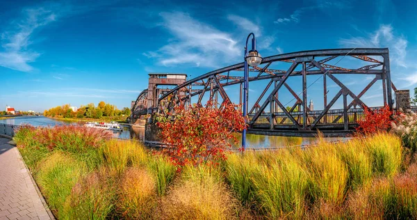 Cityscape starého železnice kovový rezavý most v červeném břečťanu listy ov — Stock fotografie
