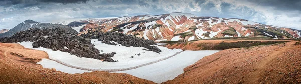 カラフルな虹火山Landmannalauar山とアイスランドの劇的な空と雪で有名なLaugavegurハイキングコースのパノラマ風景 — ストック写真