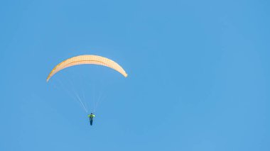 Güzel paraglider mavi gökyüzünde metin ve düz arkaplan için kopyalama alanı ile uçuyor