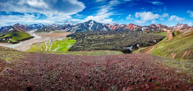 Renkli gökkuşağı volkanik Landmannalaugar dağlarındaki panoramik manzara ve İzlanda 'da dramatik gökyüzü ve karla ünlü Laugavegur yürüyüş yolu.