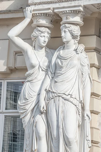 Portrait of balcony support statues of artistic young and naked sensual Roman Renaissance Era women in historical downtown of Vienna, Austria, details, closeup