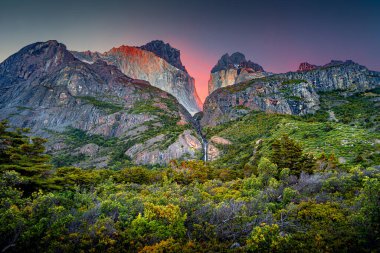 Büyük tepelerde büyülü bir gün doğumu, yüksek kuleler, dişler ve yakınlardaki şelale Torres del Paine Ulusal Parkı, Patagonya, Şili