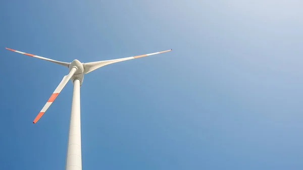 带有大风力涡轮机的横幅从塔底喷出 以发电 绿色环保能源在蓝天与日落温暖的颜色和抄袭空间的文字 — 图库照片