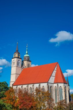 Saint Jochannis Kilisesi (Jochanniskirche) Magdeburg, Almanya 'nın tarihi merkezinde, güneşli bir sonbahar gününde ve bulutlu mavi gökyüzünde
