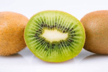 Olgun kivi meyvesi ve parlak arka planda yarım kivi meyvesi..