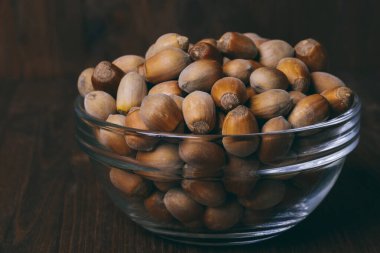 Cam kasede fındık. Tam kaçıklar. Corylus Avellana. Makro fotoğraf, yakın plan, ahşap arka plan..