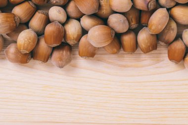 Fındık yığını. Tam kaçıklar. Corylus Avellana. Makro fotoğraf, yakın çekim, ahşap masanın üstü..