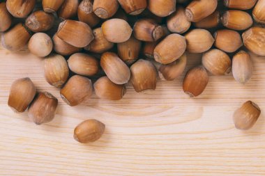 Fındık yığını. Tam kaçıklar. Corylus Avellana. Makro fotoğraf, yakın çekim, ahşap masanın üstü..