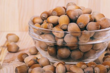 Cam kasede fındık. Tam kaçıklar. Corylus Avellana. Yakın plan, ahşap arka plan..