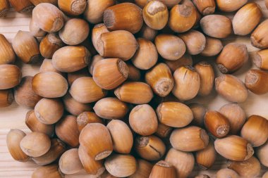 Fındık yığını. Tam kaçıklar. Corylus Avellana. Makro fotoğraf, yakın çekim, ahşap masanın üstü..