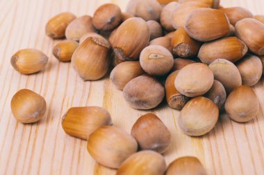 Fındık yığını. Fındık. Tam kaçıklar. Corylus Avellana. Makro fotoğraf, ahşap masaya yakın..