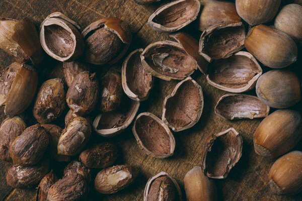 Whole nuts, shelled nuts and shells. Corylus avellana. Macro photo, close up, on wooden table. Top view.