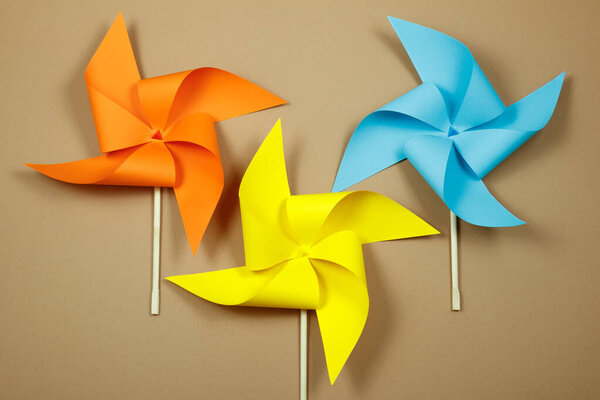 Красочные ветряные мельницы на бежевом фоне.