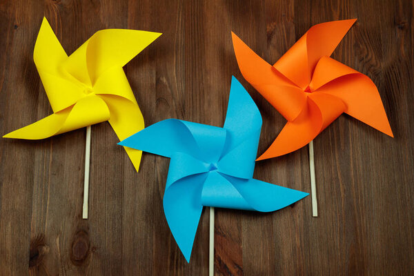 Красочные ветряные мельницы на деревянном фоне.