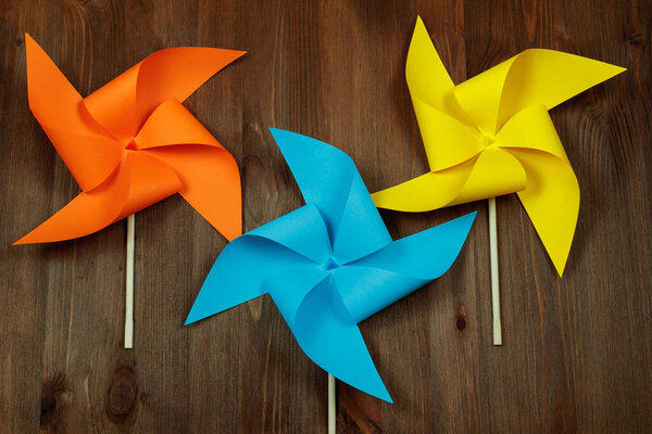 Красочные ветряные мельницы на деревянном фоне.