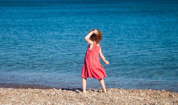 Piccola Ragazza Rossa Rosa Che Lancia Ciottoli Mare Finta Posa — Foto Stock