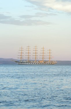 Beş direkli barquentine körfezde demirleyen.