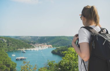 Kadın turizm kenti yakınlarındaki göl bakarak sırt çantası ile.