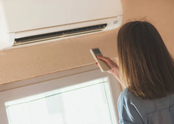 Woman Holding Remote Control Aimed Air Conditioner — Stock Photo, Image