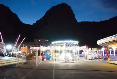 Akşam aydınlatılmış eğlence parkı.