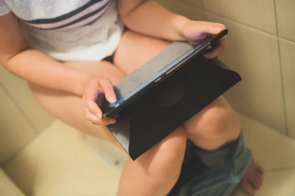 妇女使用平板电脑在厕所 — 图库照片
