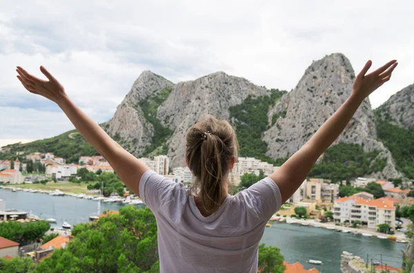 Woman with arms wide open enjoying views.