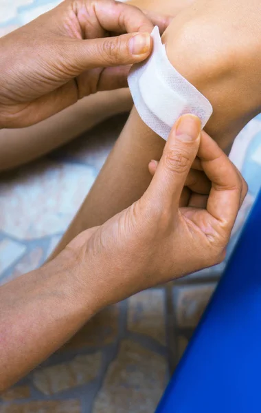 Mujer Pone Vendaje Adhesivo Rodilla Del Niño — Foto de Stock