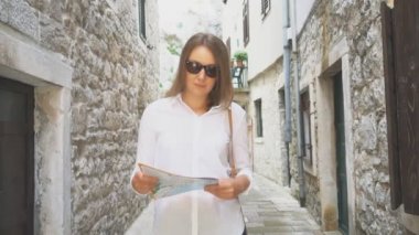 sarışın genç kadın sokakta bir harita.