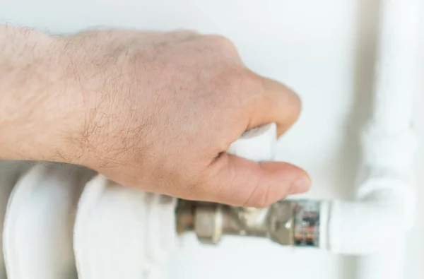 Aanpassing van de thermostaat om te schakelen op de radiator kachel thuis mannenhand. — Stockfoto