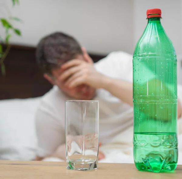 Mann Trinkt Mineralwasser Und Leidet Kater — Stockfoto