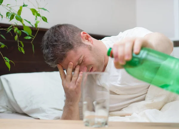 ミネラル水を飲むと 二日酔いに苦しむ男性 — ストック写真