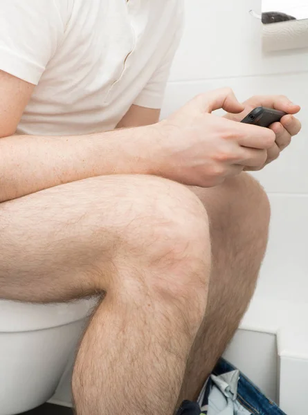 Człowiek Przy Użyciu Telefonu Komórkowego Toalecie — Zdjęcie stockowe