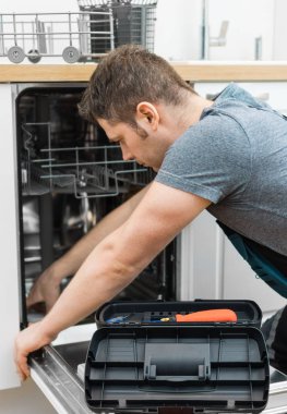Profesyonel tamirciyle mutfakta iç bulaşık makinesi tamiri tulum.
