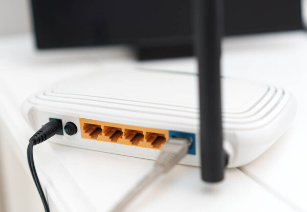 Белый беспроводной маршрутизатор стоит на столе
.