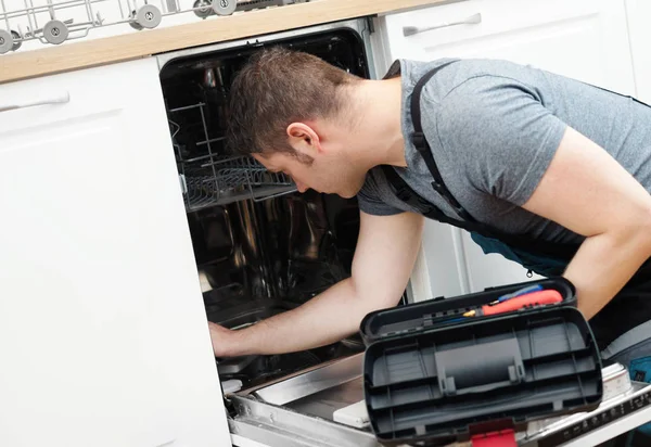 台所で国内食器洗い機の修理のオーバー オールのプロ便利屋 — ストック写真
