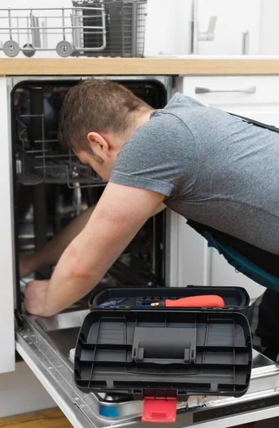 专业勤杂工在厨房里修理家用洗碗机 — 图库照片