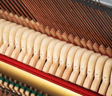 Yakın çekim görünümü içinde piyano dizeleri ve çekiç.