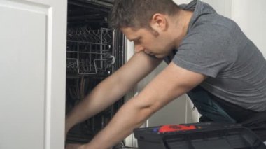 Profesyonel tamirciyle mutfakta iç bulaşık makinesi tamiri tulum.