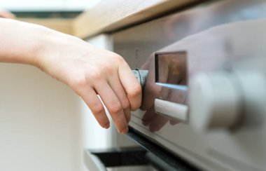 Mutfakta tehlikeli bir durum. Elektrikli fırın ile oynayan çocuk.