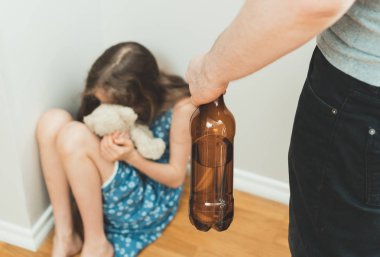 Sarhoş babası korkmuş küçük kız oyuncakla önünde. Aile içi şiddet kavramı.