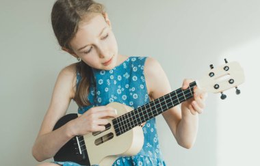 Sevimli kız ukulele evde oynamak için öğrenme.