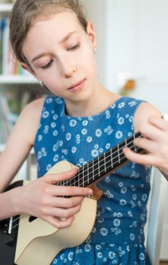 Sevimli kız ukulele evde oynamak için öğrenme.