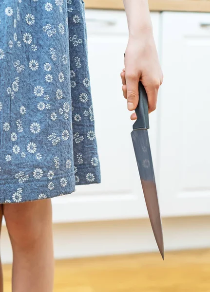 Dangerous situation in the kitchen. Child with kitchen knife in hand.