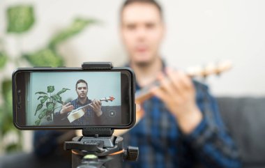 Yakışıklı adam müzik aletleri hakkında video blogu yapıyor..