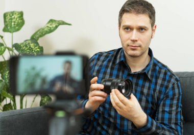 Yakışıklı adam fotoğraf makinesi lensleri hakkında video blogu yapıyor..