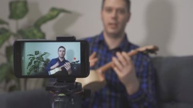 Yakışıklı adam müzik aletleri hakkında video blogu yapıyor..
