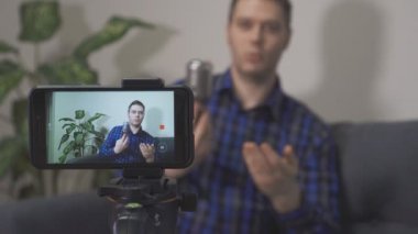 Yakışıklı adam müzik aletleri hakkında video blogu yapıyor..