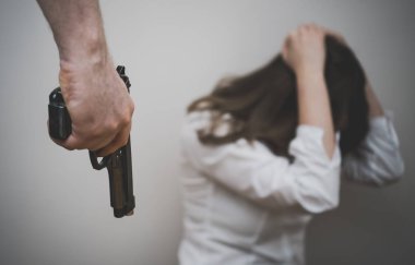 Home violence concept. Man with gun threaten woman. clipart